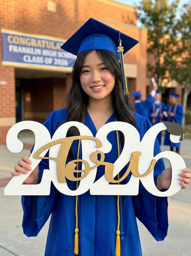 Graduating high school senior holding '2026' sign in front of Franklin High School.