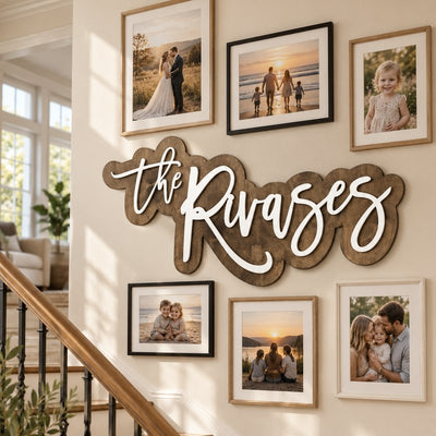 Wooden family name sign on a staircase gallery wall with family photos